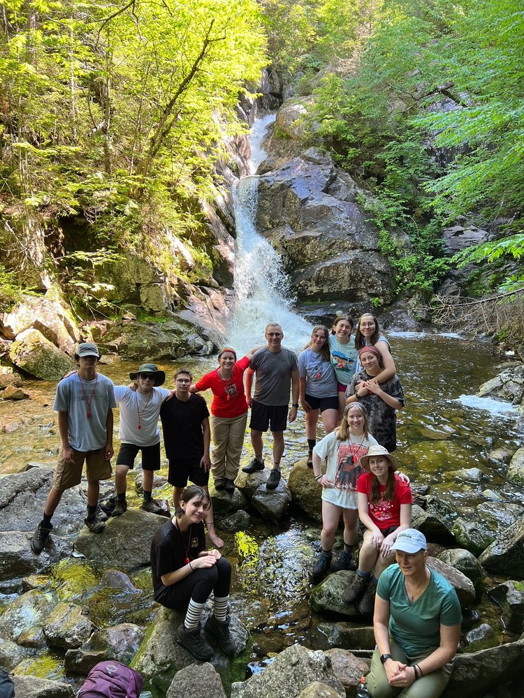 PMHS students on a hike, posing in front of a waterfall