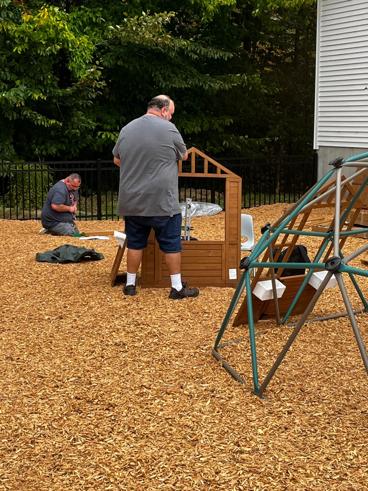 maintenance staff assembling playground equipment